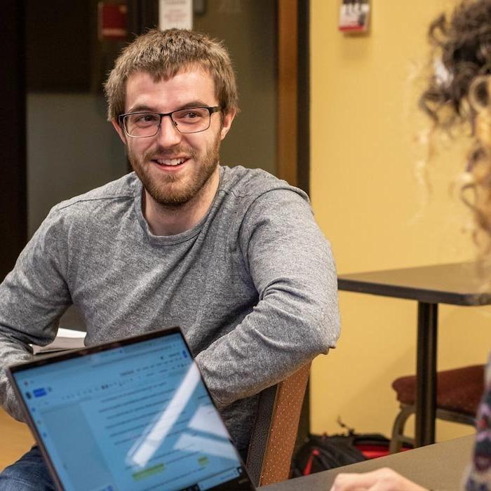 Student talks with another student in classroom